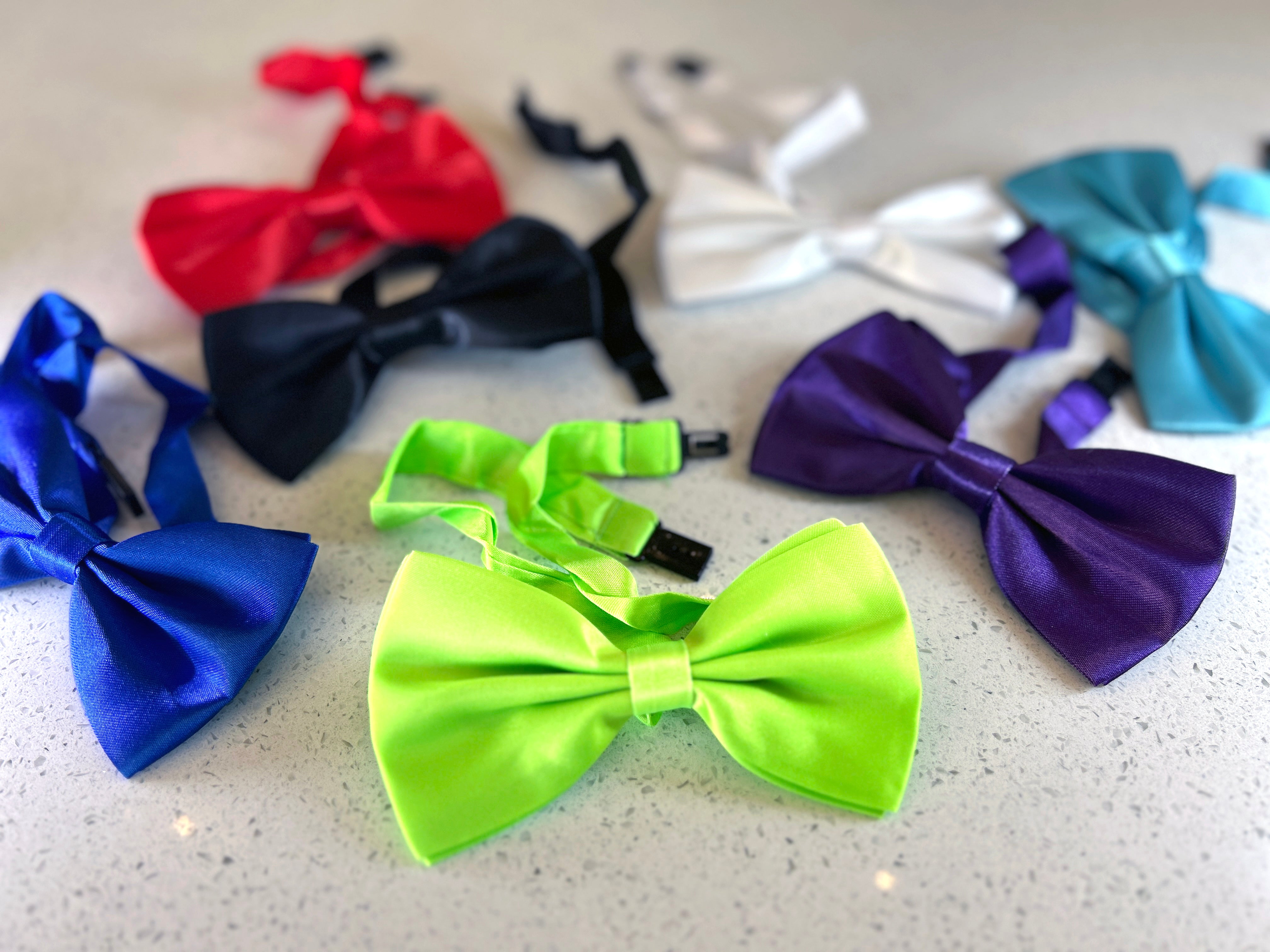 Assorted colorful bow ties on a light surface